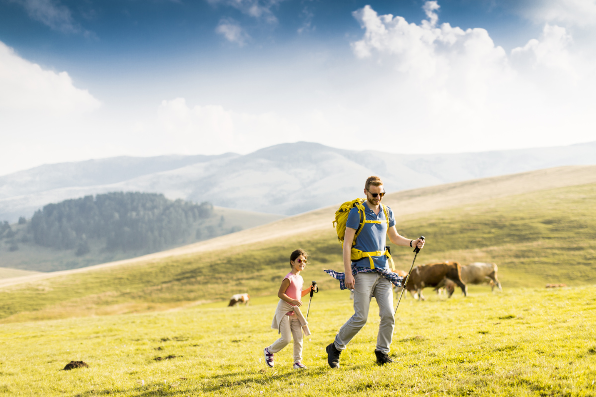 Young father and daughter enjoy hiking on a sunny day